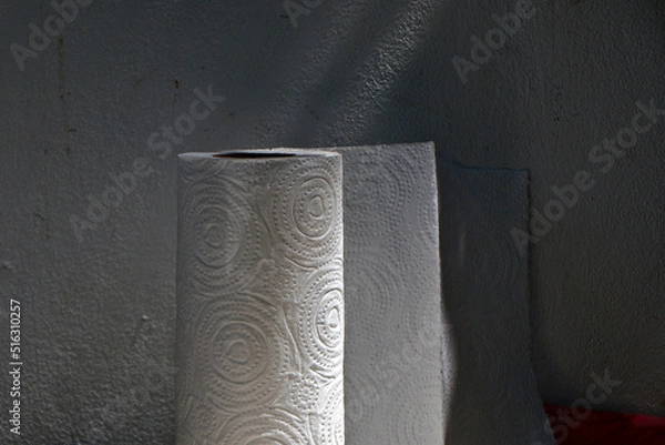 Fototapeta A large roll of tissues were placed next to the wall of the house. There was light and shadow covering it.