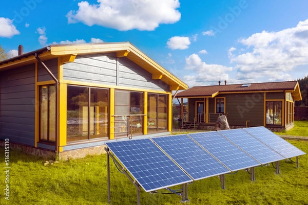 Fototapeta Solar panels under blue sky. Technologies collecting electricity from sun rays. Houses near solar traps. Eco-friendly power plant. Innovative sun panels. Alternative power supply system