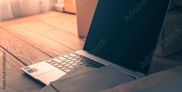 Fototapeta Desktop computer screen on white desk, interior of working room, work from home. home interior of open work space with white desk. packing parcel box for online shipping delivery. small home business.