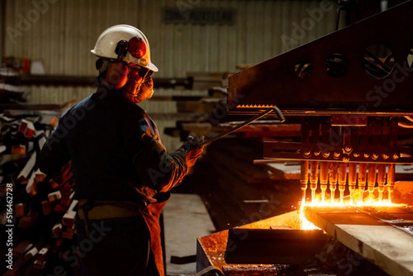 Obraz Worker checking a CNC oxy fuel cutting machine in a factory