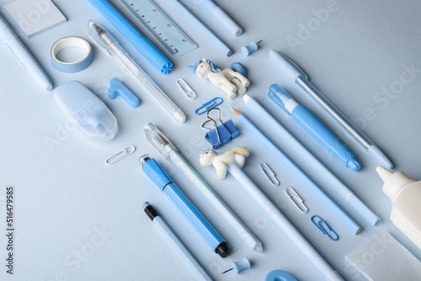 Fototapeta Background with various blue stationery lying diagonally on a light blue background. Back to school. A banner with office elements with space for text. Space for copying. Flat position, top view
