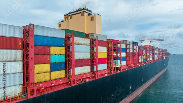 Obraz Side viewof  large cargo ship import export container box on the ocean sea on blue sky back ground concept transportation logistic and service to customer and supply change  forwarder mast