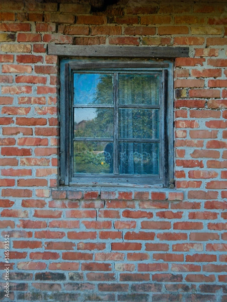 Fototapeta a glass window with a wooden frame is installed in a brick house