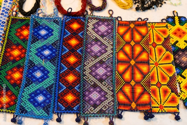 Fototapeta Handmade huichol bracelets with different colors and patterns at night market in Guadalajara, Mexico. Traditional Mexican handcraft souvenirs