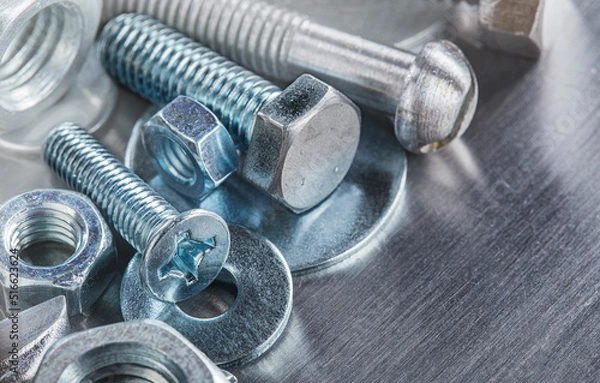 Fototapeta set of different nuts, bolts, screws, washers and drill bits,thread tap and mill cutters on steel plate background. Locksmithing deal.