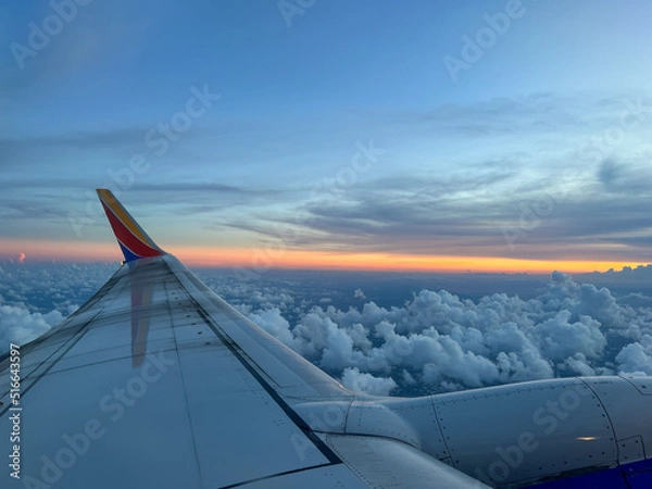 Obraz Southwest airplane wing flying above the clouds on a brigh blue sky sunny day.