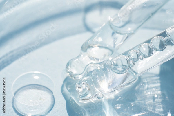 Obraz Two pipettes with transparent cosmetic liquid over blue background with copy space. Texture of face serum, hydrolate or cosmetic oil, beaty treatments. Selective focus