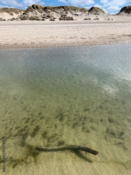 Fototapeta Wasserfläche eines Priels bei Flut mit Überblick über den Nordseestrand und die Dünen