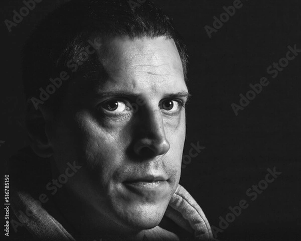 Fototapeta A reflective expression as a man looks into the camera