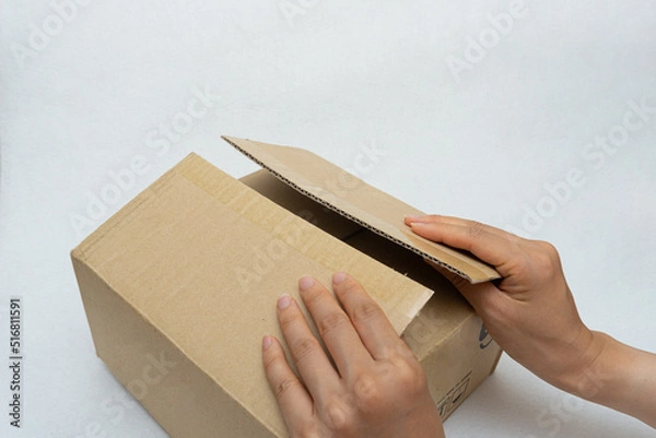 Fototapeta Unboxing the courier box with a cutter knife