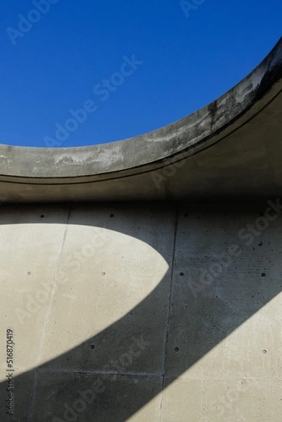 Obraz Background image for design. The curved wall with the blue sky and shadows at Sante Park Tahara, Aichi, Japan. 