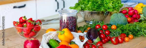 Fototapeta banner background of fresh vegetables for salad on wooden table, peppers, tomatoes, cucumbers, broccoli and greens in cozy kitchen apartment