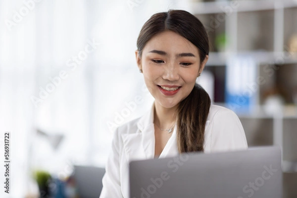 Fototapeta Business of Asian woman or accountant working on calculator to calculate business data, accounting document, and laptop computer at home office, business finances and calculate concept