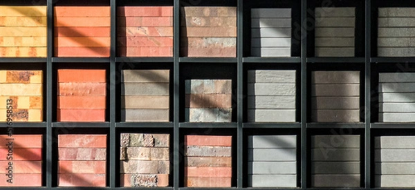 Fototapeta Stacks of various bricks on shelves. Examples of building materials
