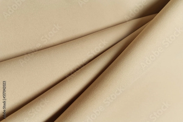Fototapeta Beige crumpled or wavy fabric texture background. Abstract linen cloth soft waves. Gabardine wool fabric. Merino yarn. Smooth elegant luxury cloth texture. Concept for banner or advertisement.