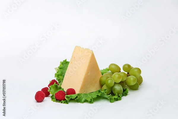 Fototapeta piece cheese with apples and tomatoes on a wooden board on a beautiful background