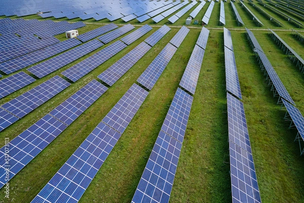 Fototapeta Aerial view of big sustainable electric power plant with many rows of solar photovoltaic panels for producing clean electrical energy. Renewable electricity with zero emission concept