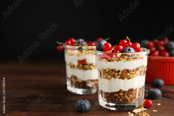 Fototapeta Delicious yogurt parfait with fresh berries on wooden table, space for text