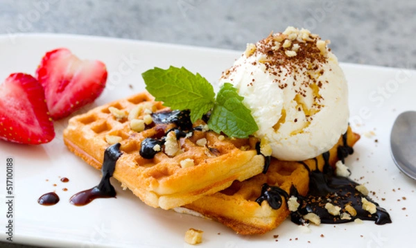 Fototapeta ice cream with Belgian waffles, strawberries, fresh mint, chocolate topping and nuts