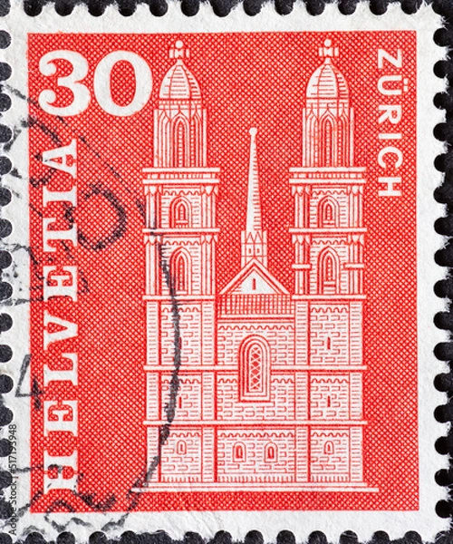 Fototapeta SWITZERLAND - CIRCA 1963: a postage stamp from Switzerland, showing the historic Swiss building the Grossmunster in Zurich . Circa 1963