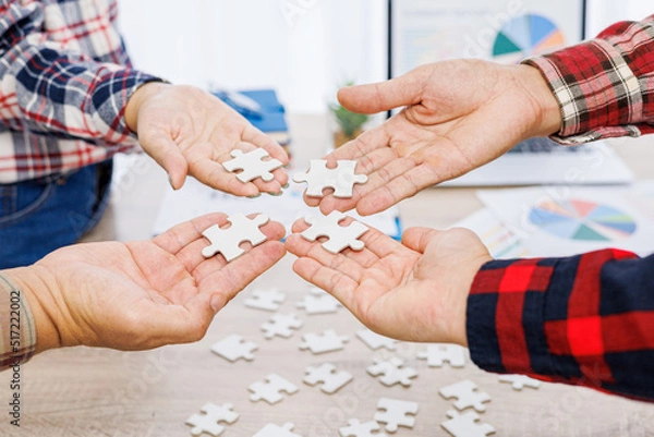 Obraz Close up Businesspeople hand holding jigsaw puzzle in a circle on the table, success and strategy concept.