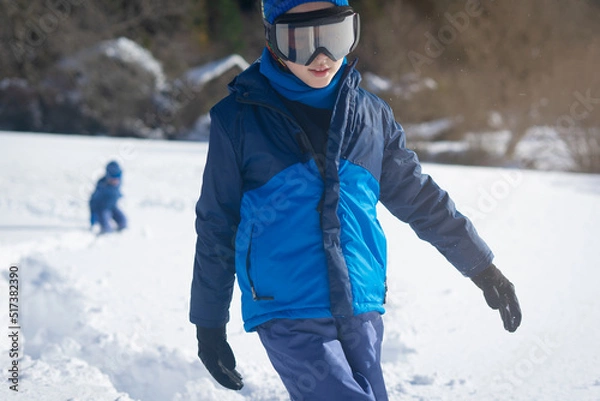 Fototapeta Boy hiking on a track knee deep in snow