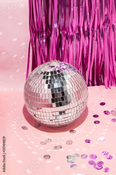 Fototapeta Shiny disco ball, courtain and confetti on pastel light pink background. Trendy party symbols concept. Minimalistic celebration composition.