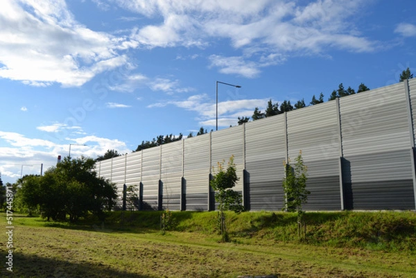 Fototapeta A noise barrier (also called a soundwall, noise wall, sound berm, sound barrier, or acoustical barrier) is an exterior structure designed to protection of people against noise.