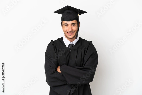 Obraz Young university graduate over isolated white background keeping the arms crossed in frontal position