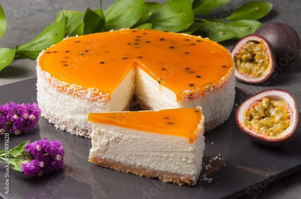 Obraz Tender cheese mass on a crispy base with a mango-passion fruit coolie filling. Decorated with passion fruit seeds on top