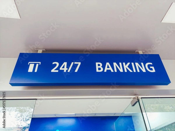 Fototapeta At the entrance to the bank, it says "banking 24/7" at the top. Bank building. The ATM is open around the clock.