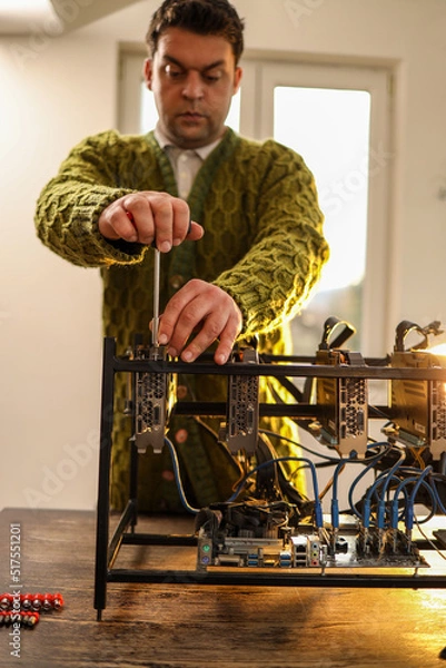 Fototapeta Man using screwdriver for setting up cryptocurrency mining rig at home