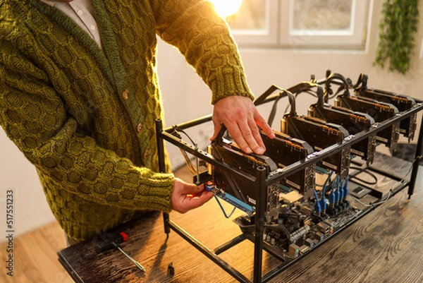 Fototapeta Man adjusting computer graphics in cryptocurrency mining rig