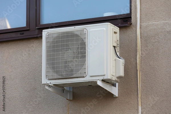 Fototapeta block of climatic equipment of the air conditioner hanging outside the building