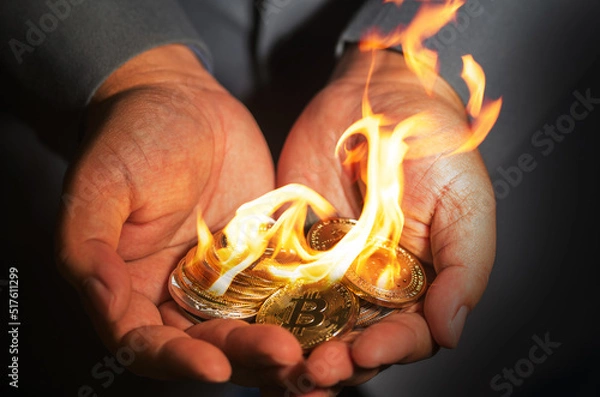 Obraz Businessman showing cryptocurrency coins burning with flame on hand