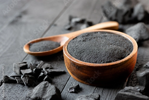 Obraz The finely crushed charcoal was placed in a cup on the black table.