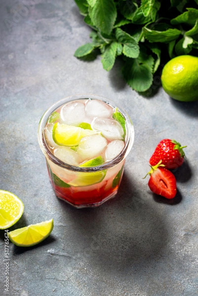Fototapeta cold detox water with lime, strawberry, mint in the glass with ice cubes on gray background