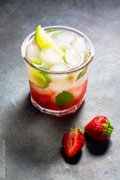 Fototapeta cold detox water with lime, strawberry, mint in the glass with ice cubes on gray background
