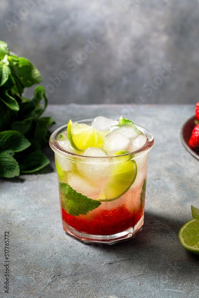 Fototapeta cold detox water with lime, strawberry, mint in the glass with ice cubes on gray background