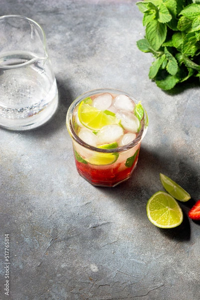 Fototapeta cold detox water with lime, strawberry, mint in the glass with ice cubes on gray background