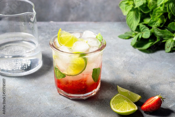 Fototapeta cold detox water with lime, strawberry, mint in the glass with ice cubes on gray background