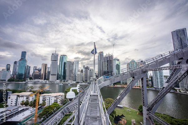 Fototapeta Brisbane city skyline viewed from the top of Story Bridge at sunset with glowing river and urban skyscrapers