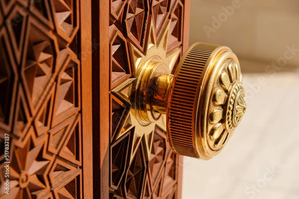 Obraz Round door handle with ornament. Antique handle on the background of a wooden door.