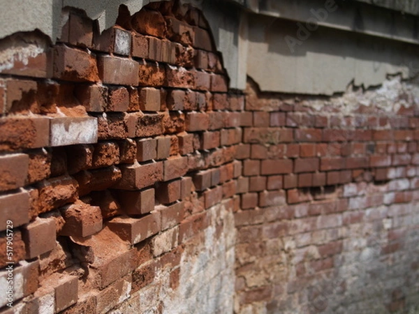 Obraz 路地の崩れかけたレンガ壁
