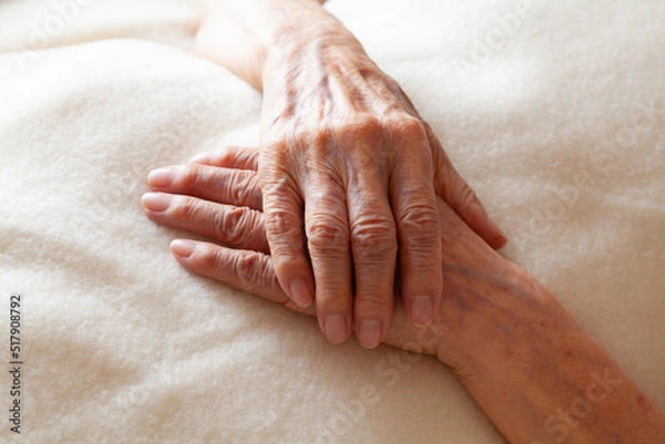 Obraz 毛布の上で組んだシニアの女性の手