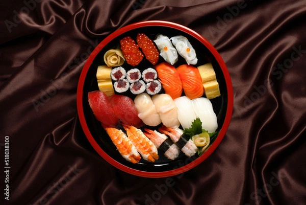 Obraz Sushi Set sashimi and sushi rolls served in traditional Japan round plate - Top view