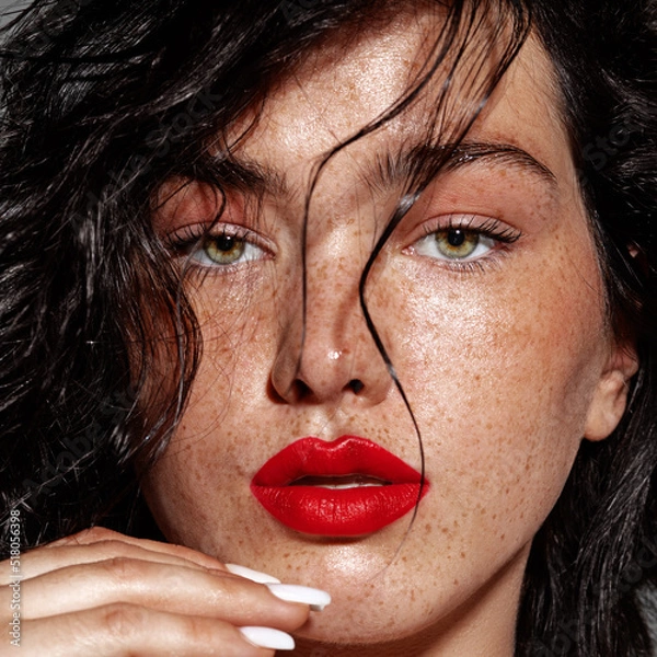 Obraz beauty young woman face with a lot of freckles and red lips, hand near face, close up