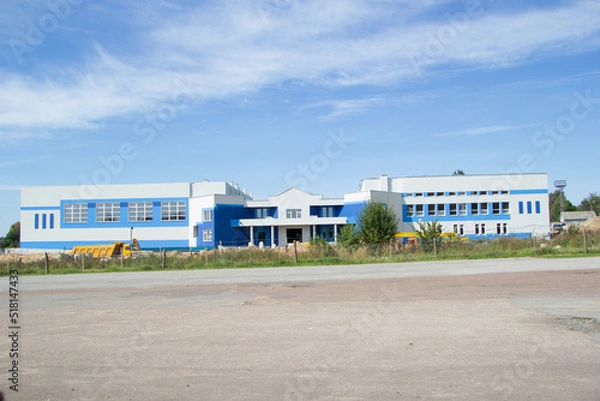 Fototapeta AGAINST THE BACKGROUND OF THE BLUE SKY, THE BUILDING OF THE SPORTS COMPLEX OR THE SWIMMING POOL