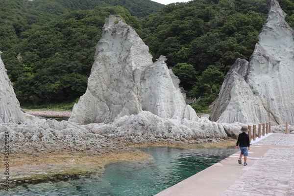 Obraz いびつな大きな岩に向かって歩く小さな男の子