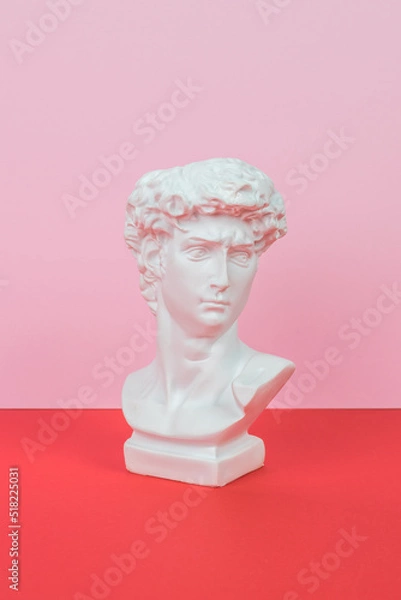 Fototapeta White plaster statuette on a red and pink background. Minimal concept.